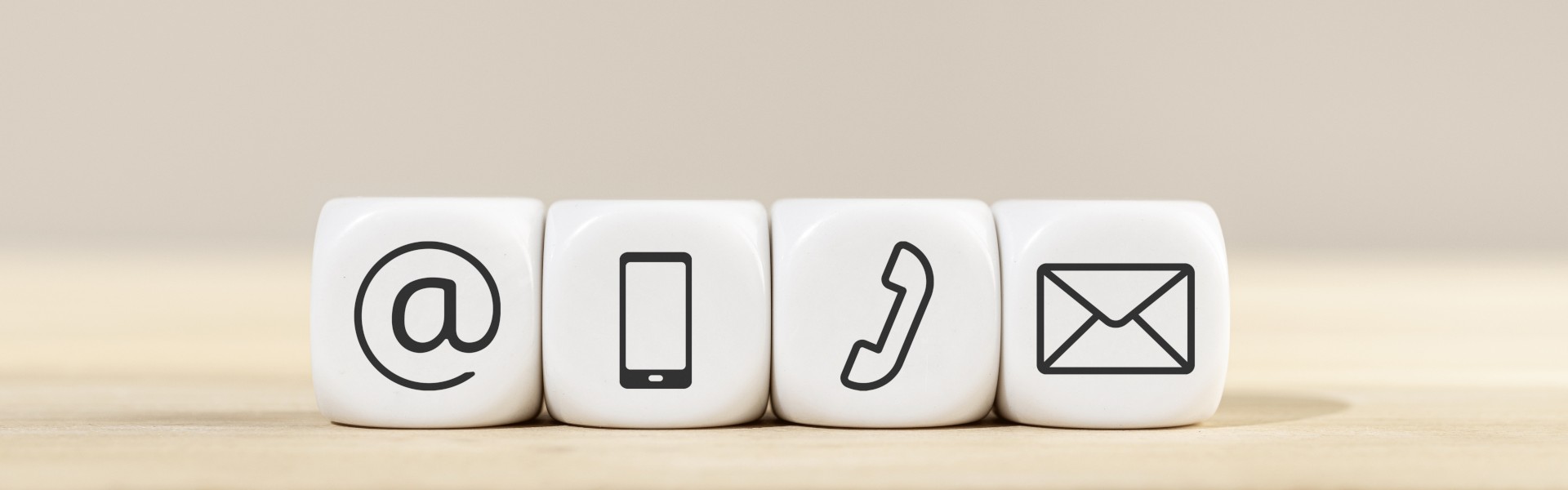 Kontakt-Symbole auf weißen Würfeln (E-Mail, Handy, Telefon, Brief).